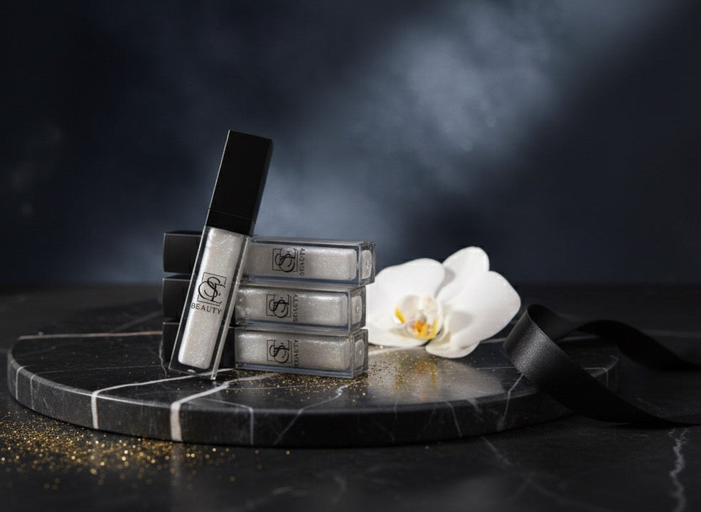 Black lip products on a dark surface with white orchids